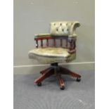 A George Smith captain's chair with green leather upholstery on swivel base