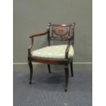 A George III style mahogany bergere elbow chair with chamfered decoration and squab cushion