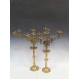 A pair of brass ecclesiastical candelabrum in the Arts and Crafts style, with adjustable arms, 61.