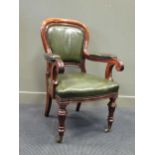 Circa 1840 a mahogany and leather upholstered library armchair with brass stud decoration