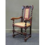 A 19th century carved oak elbow chair with woolen upholstery and barley twist decoration