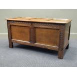 An 18th century panelled oak coffer with carved muntins over stile feet having later hinges. 61 x