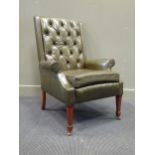 Circa 1930 a buttonback green leather library arm chair, the scroll arms over square tapering legs