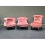 Three pink upholstered button back low chairs.