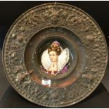 A Continental embossed metal alms-type dish marked 'Bene factum', inset with a portrait dish