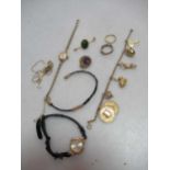 A charm bracelet tested as 9ct gold with assorted charms, an amethyst brooch stamped '9CT',