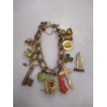 A charm bracelet and charms, the clasp marked 375 but the links unmarked and testing as base