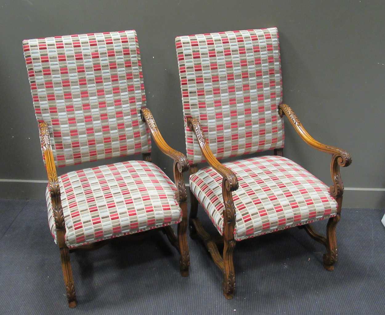 A pair of oak elbow chairs in the 17th century style, upholstered in modern rectangular panel