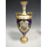 A Coalport two-handled vase, each side painted with oval scenes on a blue ground, 39cm high