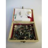 A jewellery box containing an assortment of costume jewellery and beads