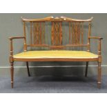 An Edwardian mahogany and satinwood inlaid settee, in Art Nouveau style, with interlaced pierced
