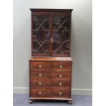 A George III figured mahogany secretaire with associated bookcase top, dentil cornice, astragal