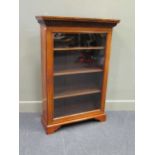 An early Victorian walnut bookcase with single glazed door on bracket feet, with key. 116 x 79 x