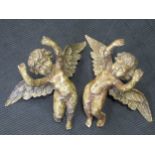 A pair of 20th century carved wood and gesso hanging cherubs and a pair of brass Dutch style light