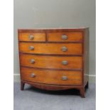 A George III mahogany and cross banded chest of drawers,oval brass handles, on splay bracket feet,