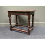 An 18th century oak side table, the two plank rectangular top with a carved frieze rail on four