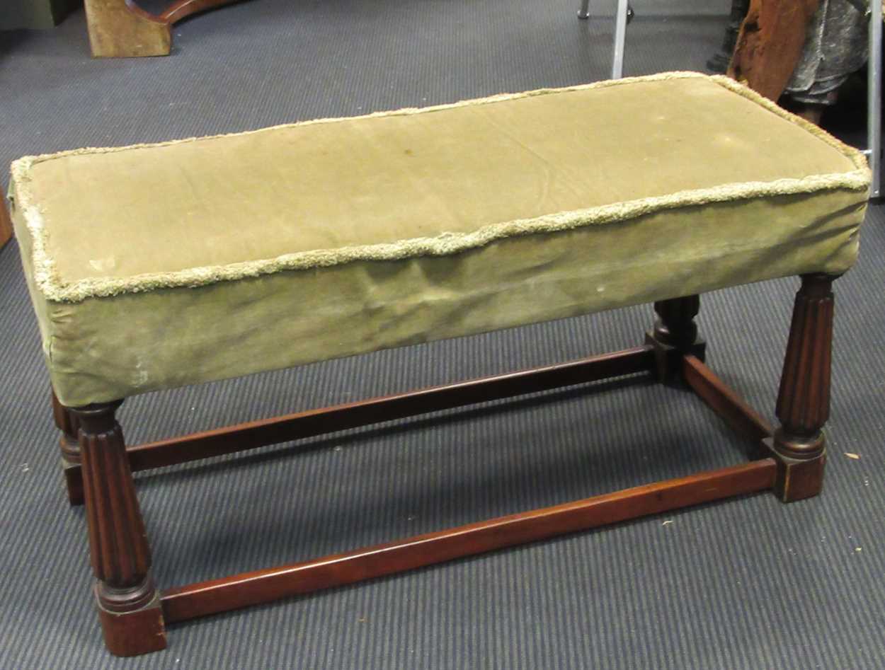 A rectangular mahogany footstool, with green upholstery on four reeded legs and stretchers 49 x