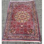 A Persian style rug, ivory and pink reserve, burgundy red ground, 135cm x 93cm approx; and a Turkish