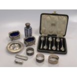 A pair of silver salts, napkin rings, cased spoons and a small dish, a metal mounted scent bottle, a