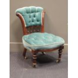 A Victorian nursing chair upholstered in green button velvet