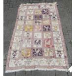 A tribal pale ground rug with bands of animals in squares and repeating border pattern, now