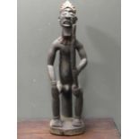 An African carved wood figure of a seated male smoking a pipe 109cm