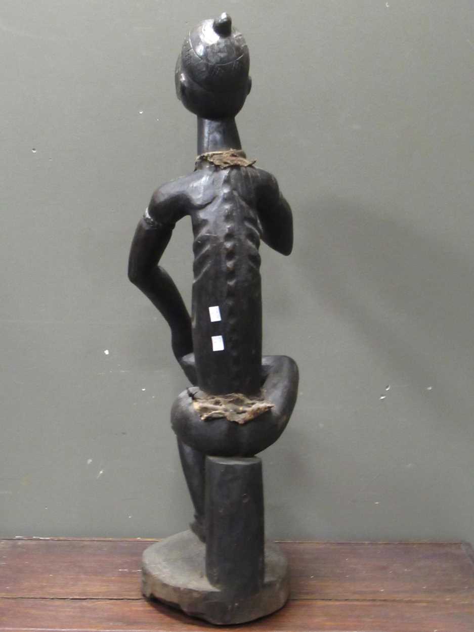 A 20th century African carved figure of seated male smoking a pipe, mirror insert to the side of the - Image 3 of 9