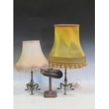 A pair of brass lamps with tripod bases and a desk lamp