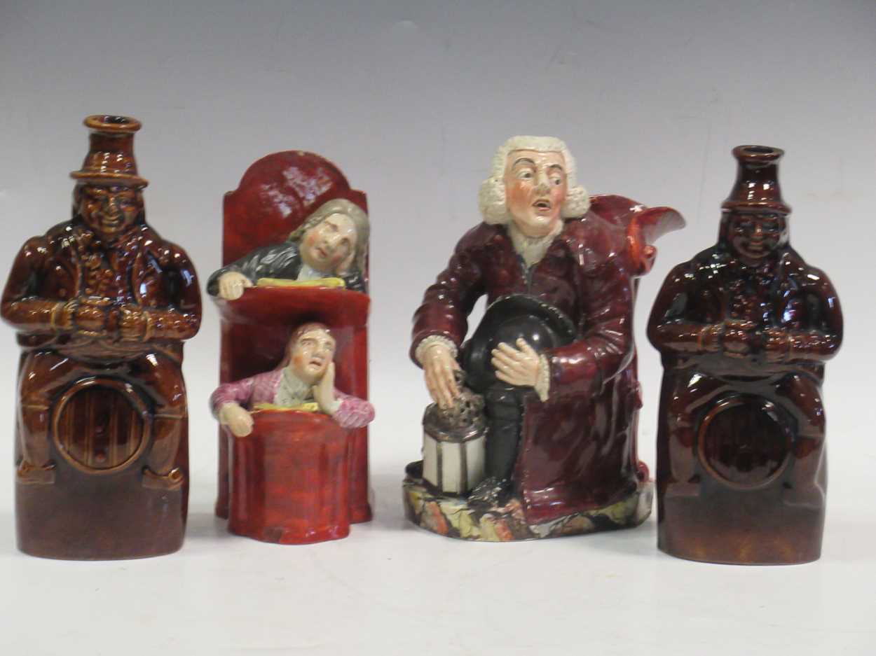 Two treacle glazed spirit flasks modelled as 'Old Tom'; a Staffordshire figure of 'The judge and the