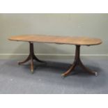 A George III style mahogany twin pedestal dining table with one leaf, early 20th century, the