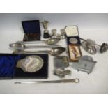 A small collection of silver wares, including a cased butter shell, an oval inkwell, a Shakespeare