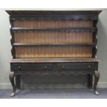 A black painted dresser, with two shelved plate rack above two long drawers on cabriole front legs