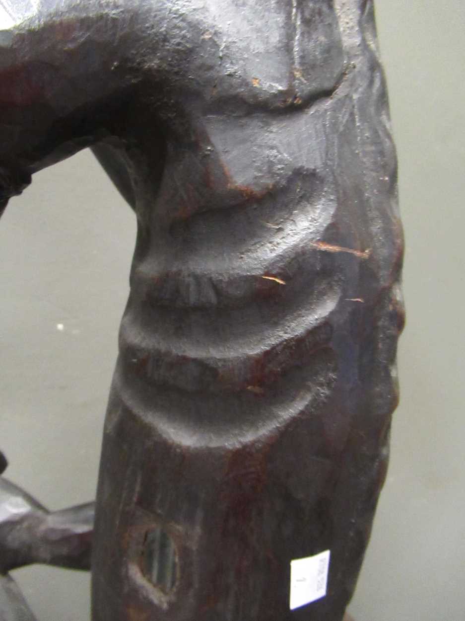 A 20th century African carved figure of seated male smoking a pipe, mirror insert to the side of the - Image 4 of 9