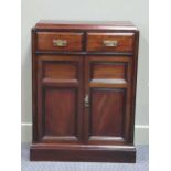 A late Victorian mahogany narrow cabinet, the two drawers over a two door cupboard on a plinth