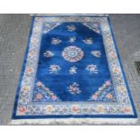 A Chinese wool carpet, with floral sprigs, on a blue ground with ivory border, approx. 375cm long,
