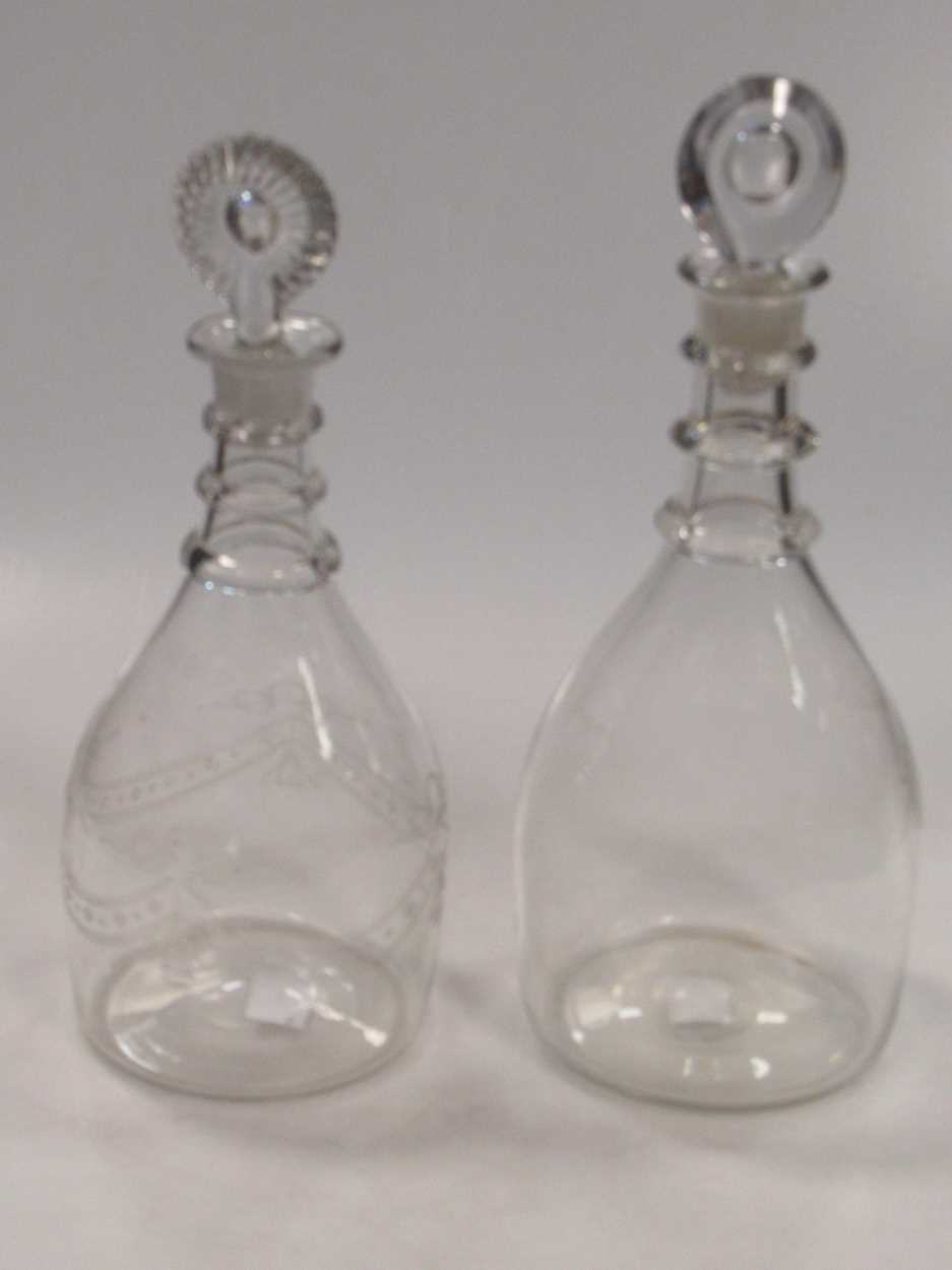 Two 19th century tripple neck ring decanters and stoppers, one engraved with swags and foliage