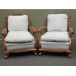 Circa 1910 a pair of walnut bergere armchairs with feather filled cushions and acanthus leaf