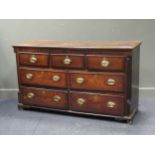 A George III oak dresser base with arrangement of three three short and four long drawers with
