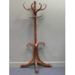 A "Thonet" style bentwood half round wall hat/ stick stand on outswept tri-legs 186cm high