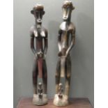 A pair of Senufo style rhythm pounders, comprising of a male (132cm high) and female (129cm high)