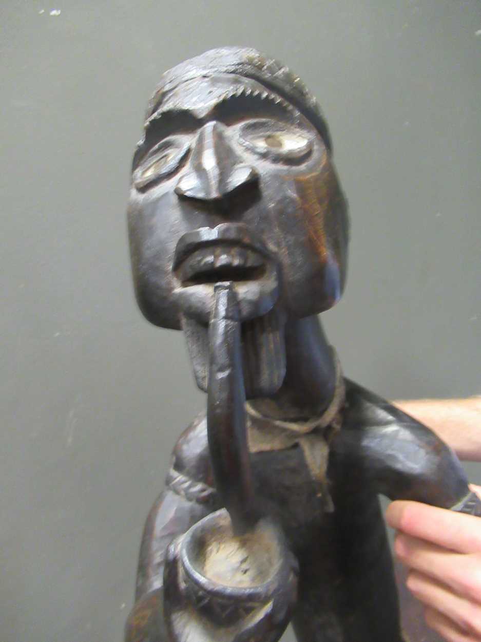 A 20th century African carved figure of seated male smoking a pipe, mirror insert to the side of the - Image 9 of 9