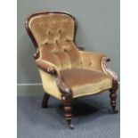 A mid-Victorian mahogany button back scroll carved armchair on turned legs and ceramic castors