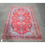 A red ground carpet with central medallian and floral decoration 384 x 242cm