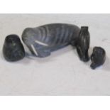 A collection of four soapstone Inuit carvings, including a walrus, a seal, a seal head and a