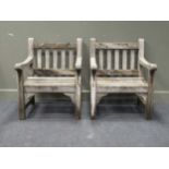 A pair of hardwood garden armchairsCondition report: Both chairs are in a weathered condition