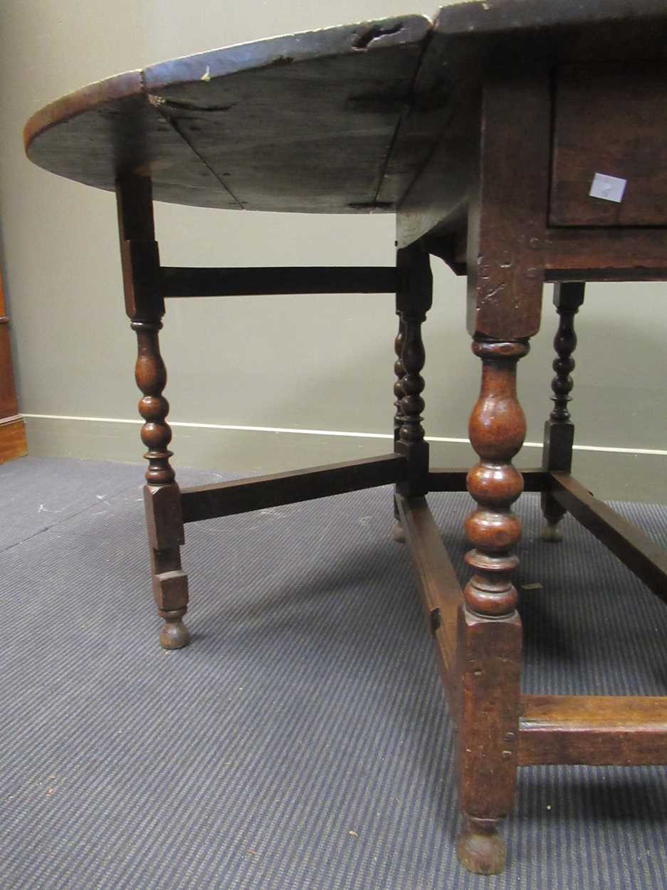 A 19th century oak gateleg table with single end drawer on turned legs 74 x 108 x 141cm open and - Image 2 of 4