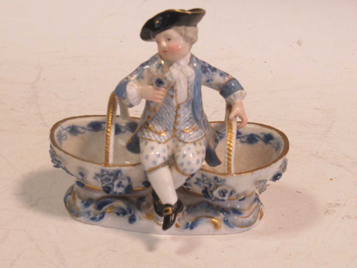 A Meissen sweetmeat figural basket, crossed swords mark