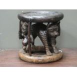 A Bamileke circular stool, with carved leopard and standing figure supports 40cm high and 40cm