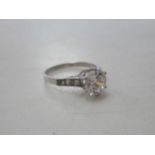 A cubic zirconia single stone ring with diamond set shoulders, worn stamp 'PLAT', weight 3.5g