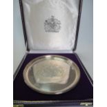 A limited edition cased silver dish featuring the Royal Coat of Arms, 20cm diameter, with